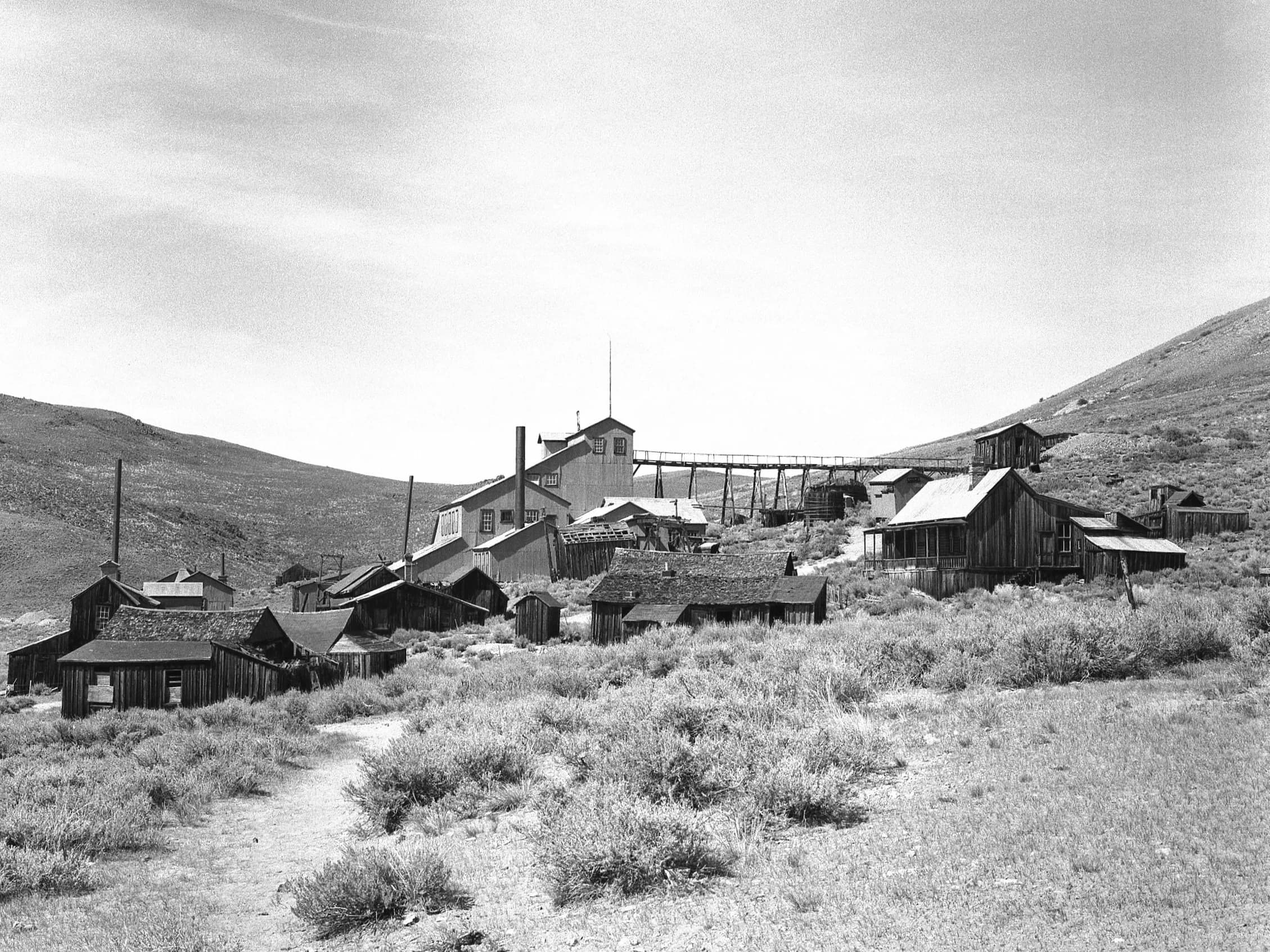 Wide view of the Bodie ghost town with weathered wooden buildings.