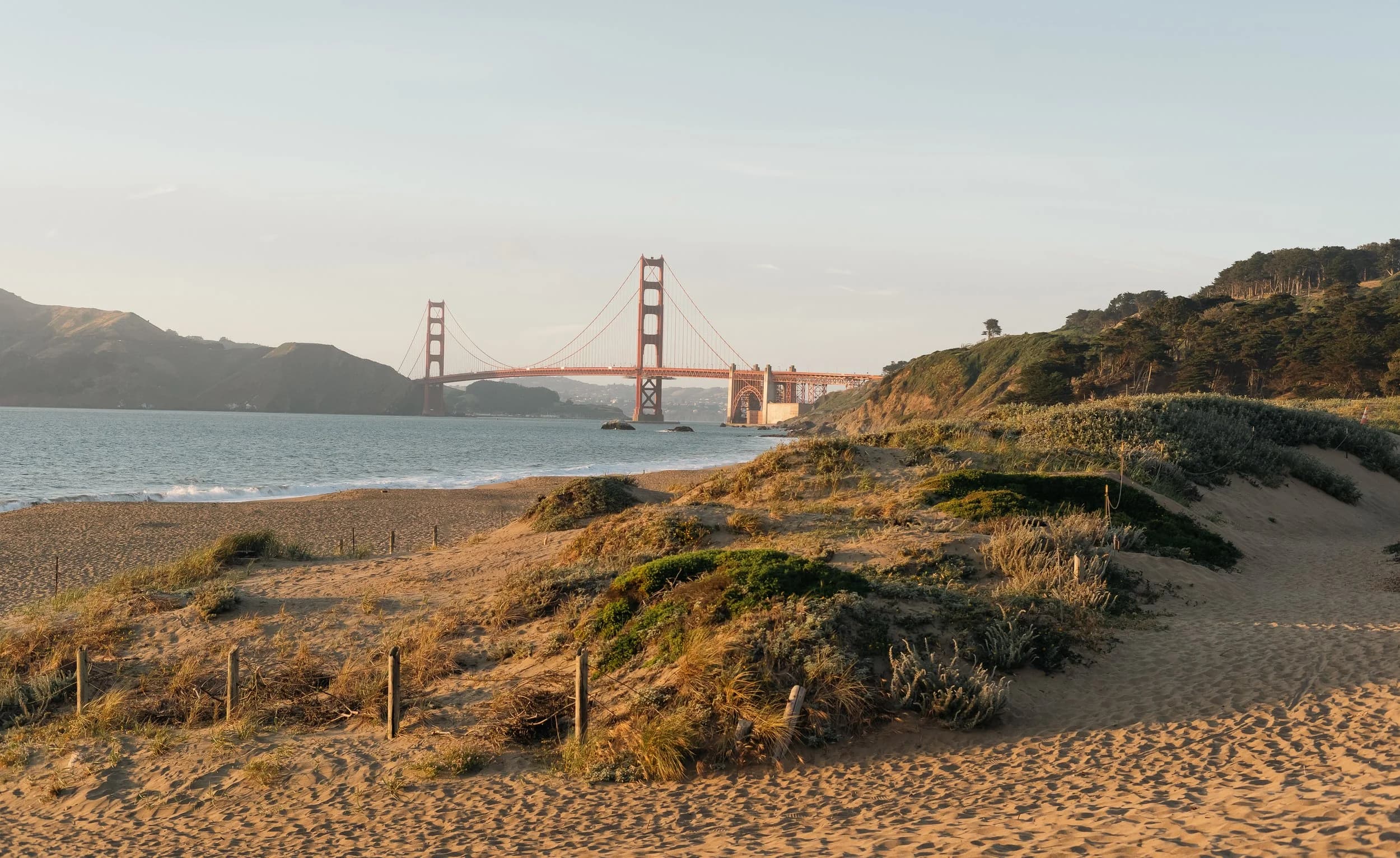 The Golden Gate Bridge seen from Baker Beach at golden hour.